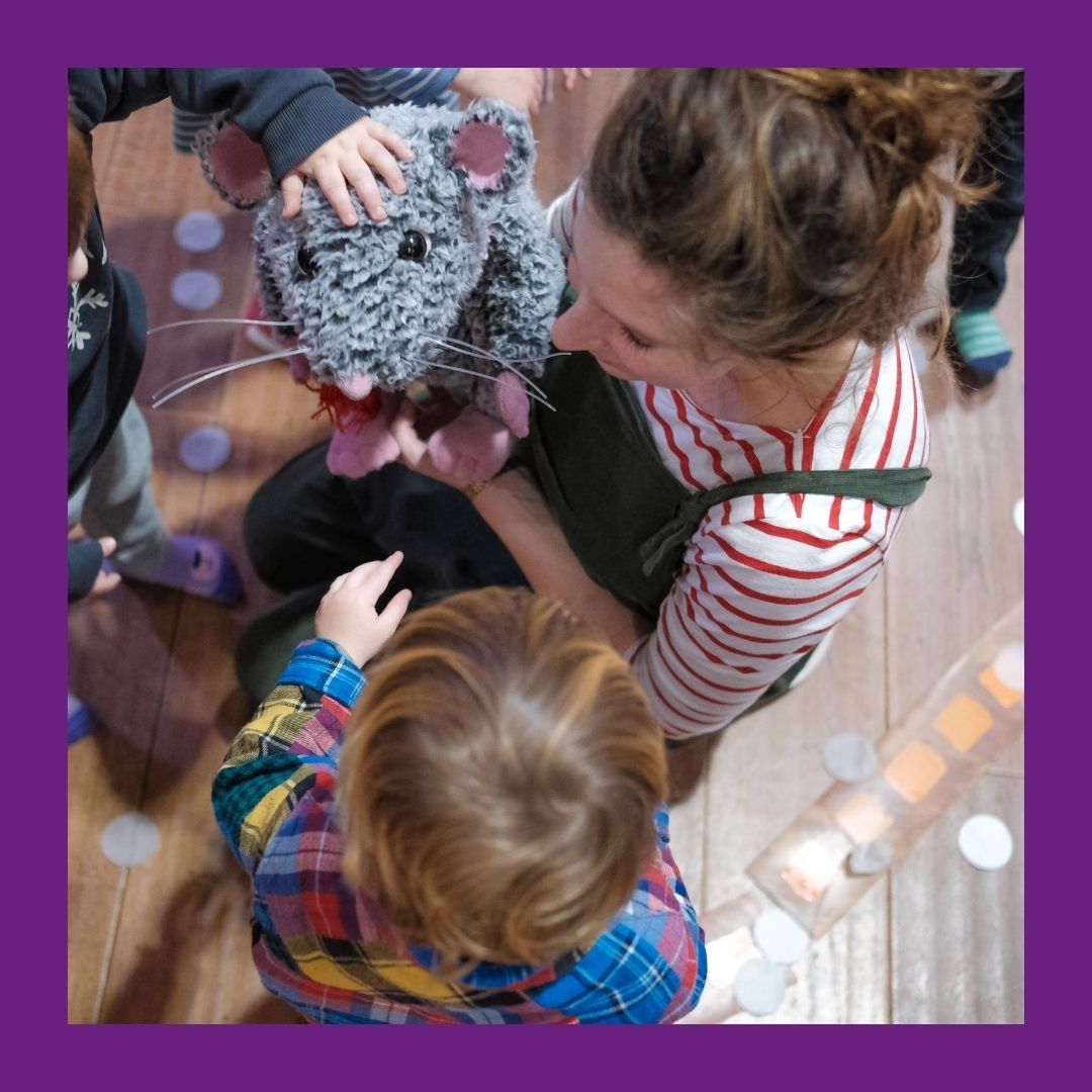 image of an adult and child playing with a rat puppet