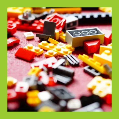 A picture of LEGO pieces scattered on a carpet.