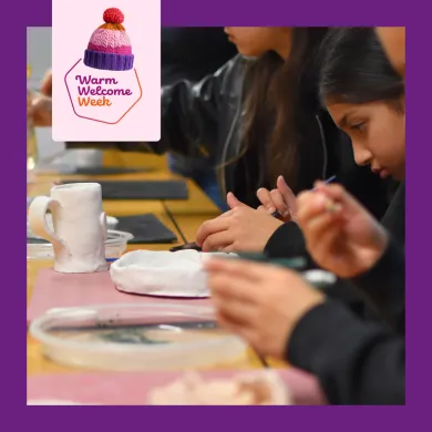 A photo of children and adults at a table shaping and glazing clay